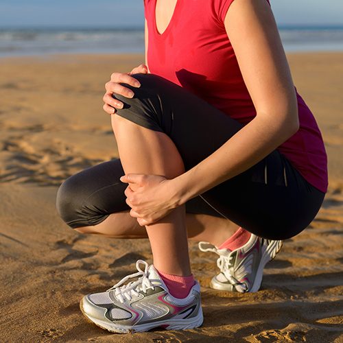 Chronic Pain Round Rock TX Lady On Beach With Knee Pain